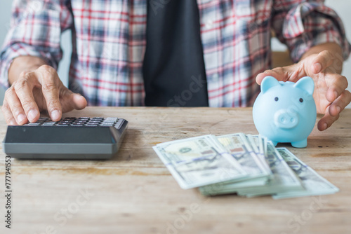 Businessman uses a calculator to calculate money,saving concept,soft focus.