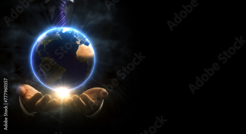 地球を模した球体を手中に収めるスーツ姿の男性の手と光 都市伝説・掌握・陰謀・操作・世界のイメージ