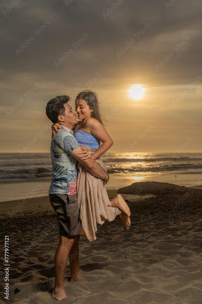 Romantic man holding his girlfriend on the beach at sunset time