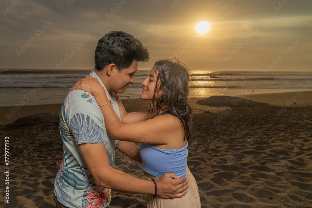 Couple in love about to kiss on the beach at sunset time