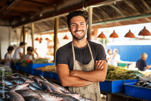 An attractive male fisherman at a fish stall in the market