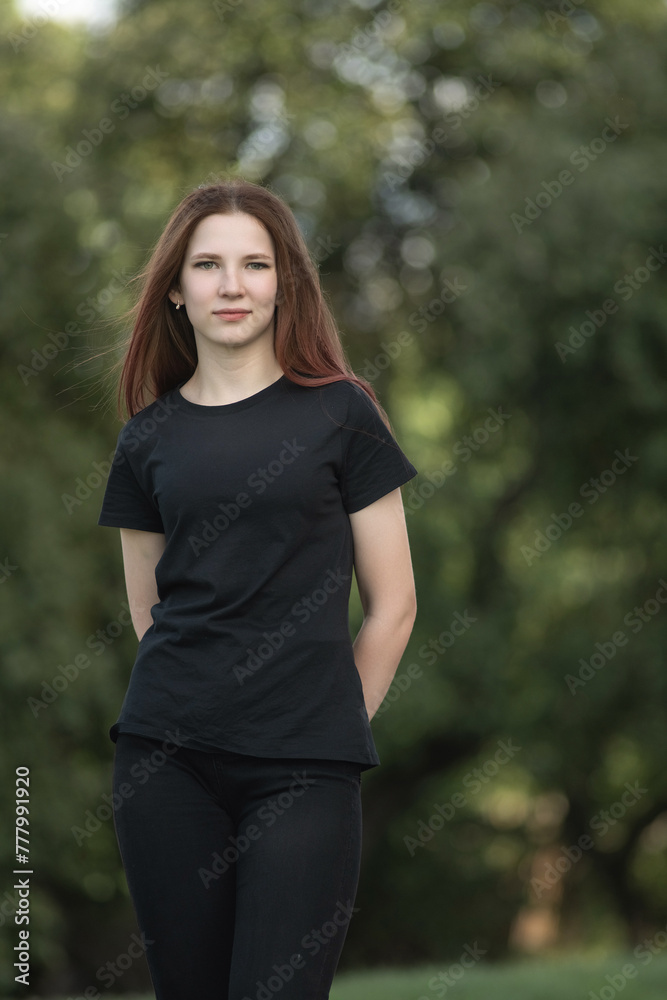 Portrait of a young beautiful long-haired girl outdoors in dark clothes. Portrait of a young beautiful long-haired girl outdoors in dark clothes.