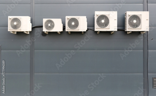 Five air conditioners installed on the wall of the store