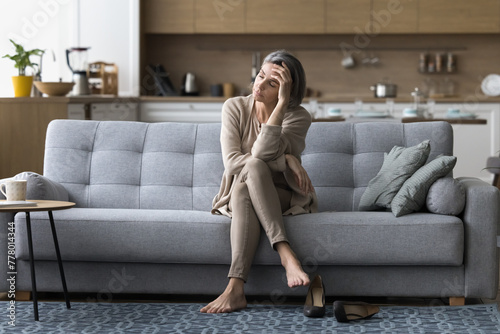 Canvastavla Drained mature woman came home after long stressful workday took off her shoes,