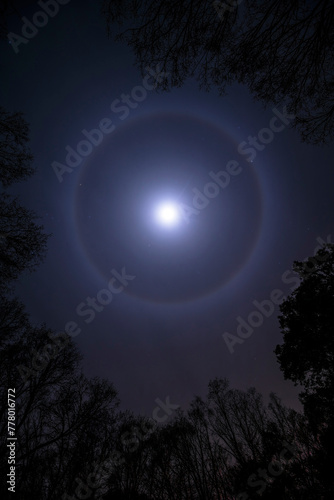 Mystical halo around the moon on a dark night