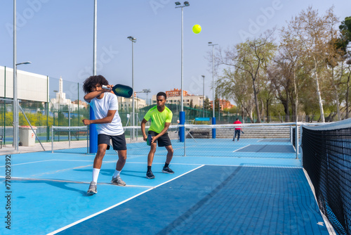 African sportive friends playing pickleball together outdoors photo