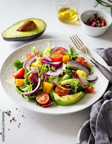 A vibrant salad featuring chunks of avocado, mixed greens, cherry tomatoes, and red onion, dressed lightly, served on a white porcelain plate, emphasizing health and freshness