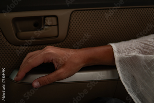 Photography woman hand resting on an armrest in a car, traveling background