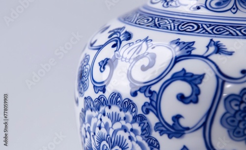 The abstract art on the blue and white ceramic vase in detail. There is only white in the background.