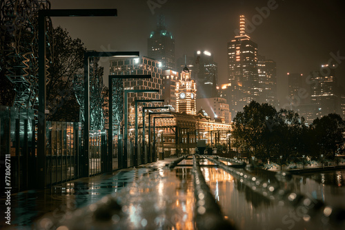 The night view of the Flinders Street Railway Station and Skyscrapers in Melbourne City in the rain