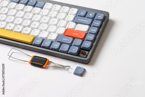 Cute and slim mechanical keyboard with one disassembled key button. Programming keyboard on a white background
