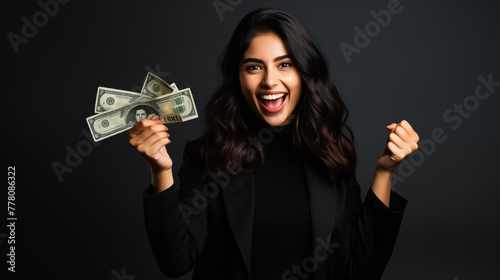 Portrait of a cheerful young woman holding money banknotes. Young woman holding cash dollars and looking happy at camera. Credit and loan concept