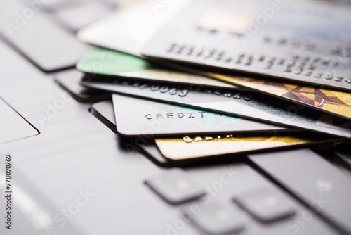 Colorful stack of credit cards and shopping gift cards on laptop keyboard. Selective focus. Macro with shallow dof.