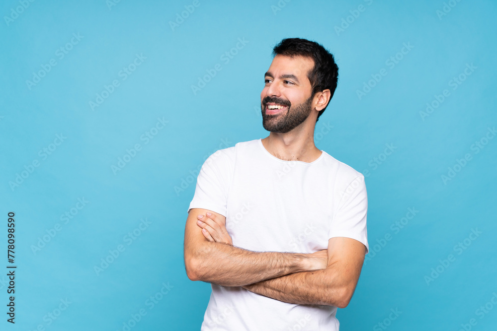 Fototapeta premium Young man with beard over isolated blue background happy and smiling