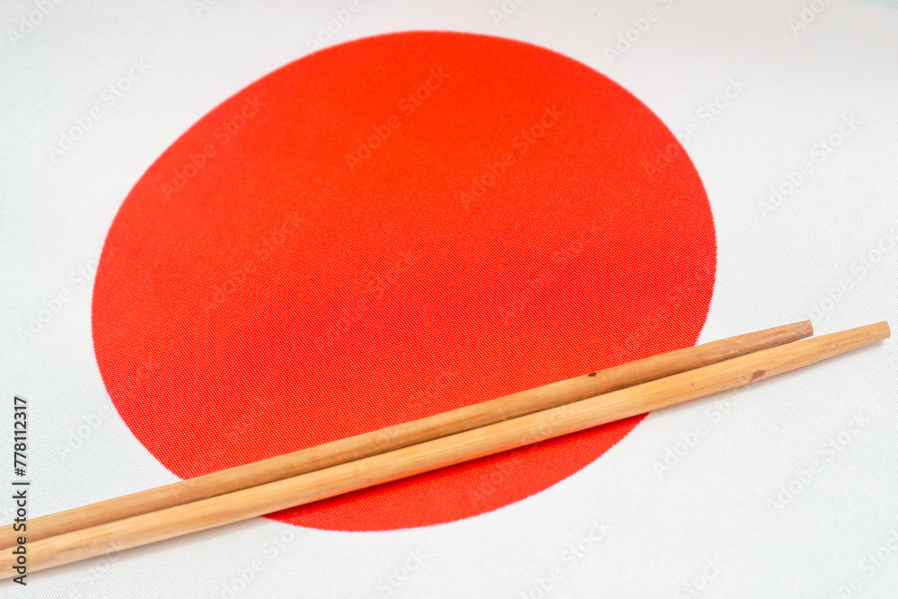Sushi chopsticks lie on the background of the national flag of Japan Sushi chopsticks lie on the background of the national flag of Japan