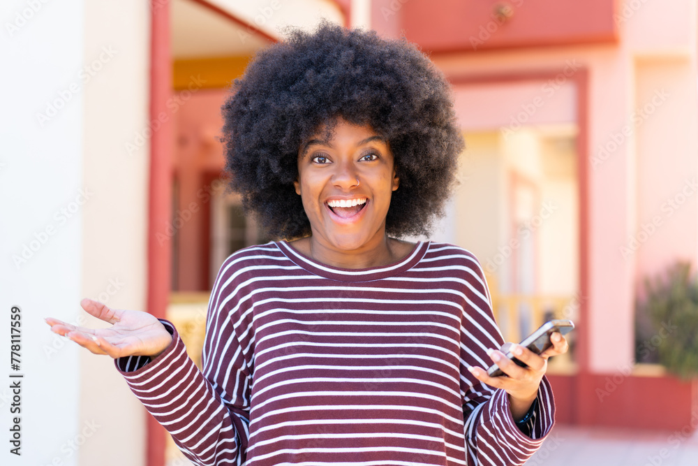 African American girl using mobile phone at outdoors with shocked facial expression African American girl using mobile phone at outdoors with shocked facial expression