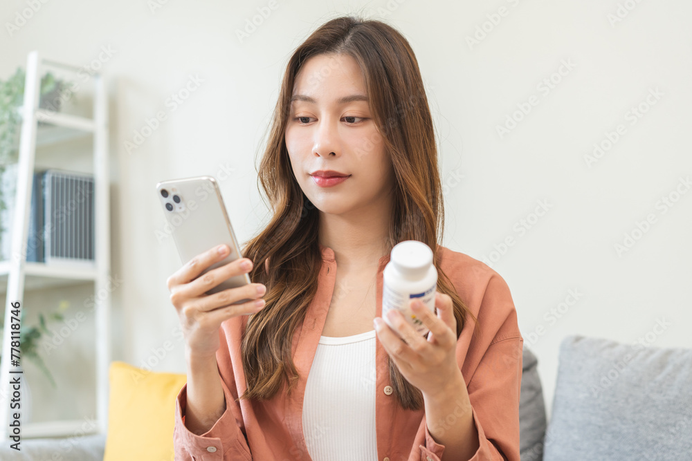 Health care asian young woman using smart phone for reading, searching prescription on bottle medicine, pill label text about information online, instructions side effects, pharmacy medicament concept Health care asian young woman using smart phone for reading, searching prescription on bottle medicine, pill label text about information online, instructions side effects, pharmacy medicament concept