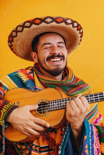 Man in poncho and sombrero playing ukulele on a yellow background