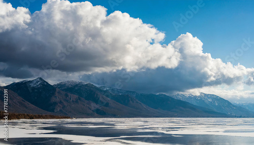 Thunderclouds over a frosty bay with mountains, dramatic sky with cumulus clouds, nature and meteorology abstract background © Nolan