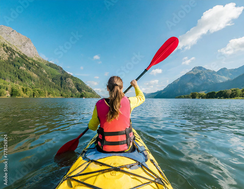 Back view shot of young woman tourist paddling on kayaking on beautiful lake in sunny day on natural mountains backgrounds, Active lifestyle, active water sports, spring summer outdoor activities