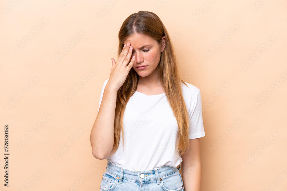 Young caucasian woman isolated on beige background with headache Young caucasian woman isolated on beige background with headache