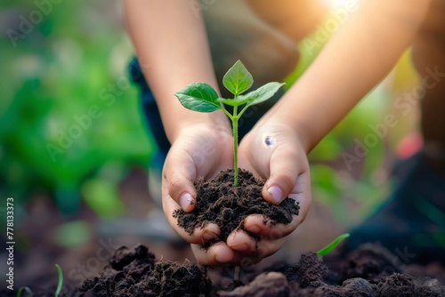 Hands hold a handful of earth with a plant sprout, symbolizing care, environmental friendliness and hope in the process of natural interaction photo