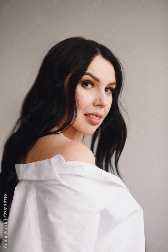 Portrait of attractive brunette woman in white shirt posing in the studio. Beautiful makeup Portrait of attractive brunette woman in white shirt posing in the studio. Beautiful makeup