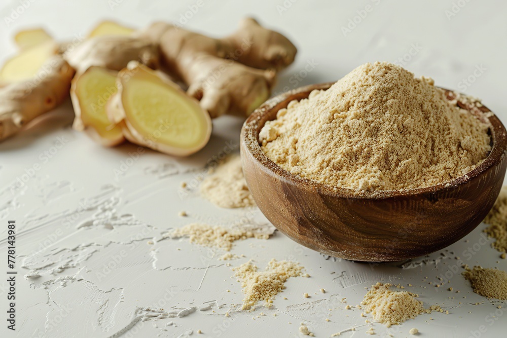 Ginger root and ginger powder in a wood bowl. Fresh ginger rhizome with sliced over light grey concrete background. Zingiber ground spice for cooking. Herb medical concept. Natural organic ingredient Ginger root and ginger powder in a wood bowl. Fresh ginger rhizome with sliced over light grey concrete background. Zingiber ground spice for cooking. Herb medical concept. Natural organic ingredient