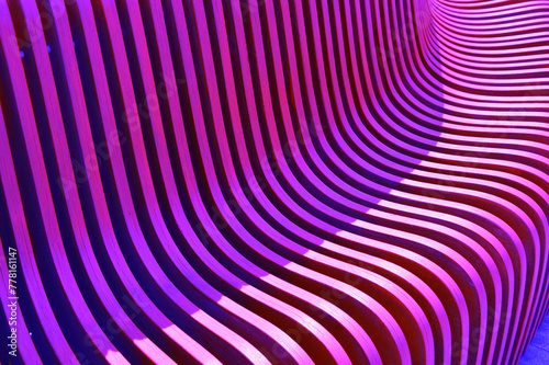 Purple pink wooden curved slats, planks, boards. Element of building facade, benches. Beautiful abstract background.