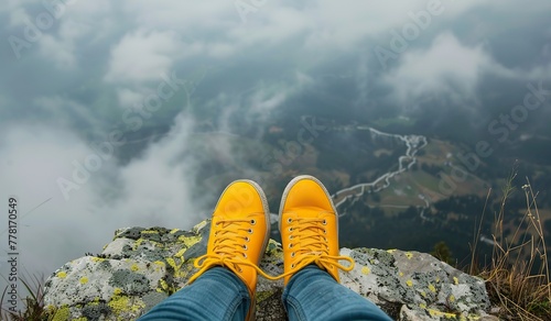 Yellow boots against a backdrop of misty mountains. The concept of exploration and discovery.