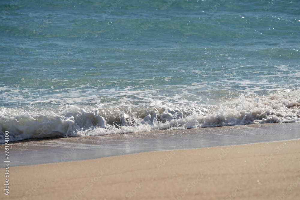 Waves rolling on a sandy beach on a sunny day Waves rolling on a sandy beach on a sunny day