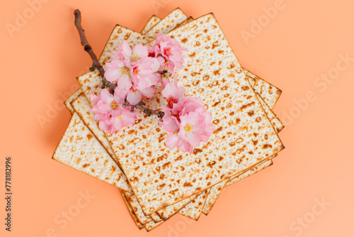 Matzo, decorated with almond flowers. On a peach background. Pesach/Passover holiday