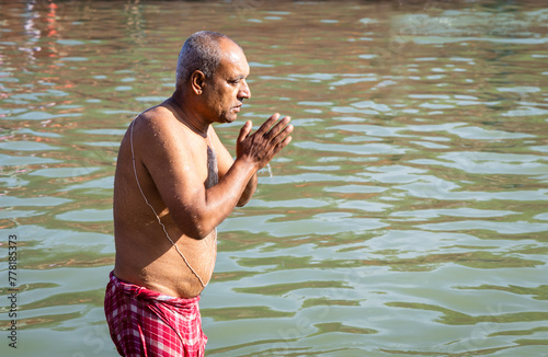 devotee praying after bathing in holy river water at morning from flat angle