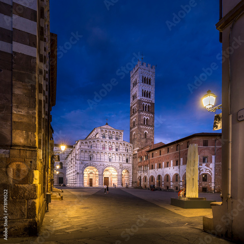Lucca, Italy - July 29, 2023: Romanesque façade and bell tower of Saint Martin’s Cathedral in Lucca, Tuscany. It contains the most precious relic of Lucca