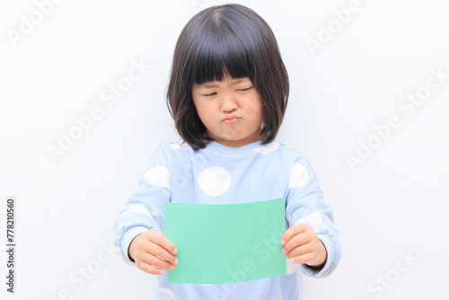 コピースペース用の紙を持った3歳の女の子