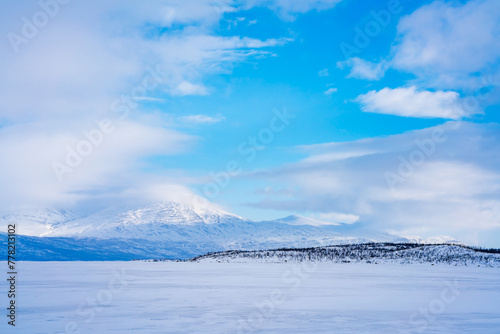 Frozen lake Tornetrask and snow covered mountains around Abisko, Sweden photo