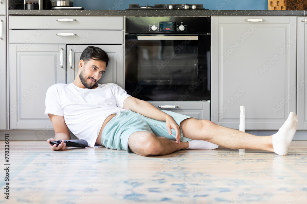 Tired man sitting on the floor after exhausted cleaning day at home Tired man sitting on the floor after exhausted cleaning day at home