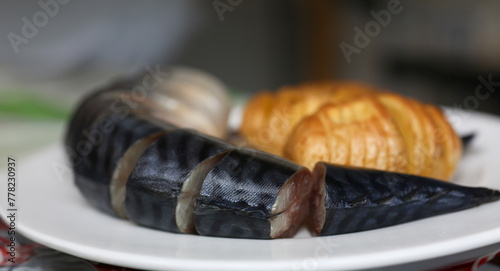 Baked golden potatoes with herring mackerel fish on a white plate. Traditional dish of English cuisine chips and fish