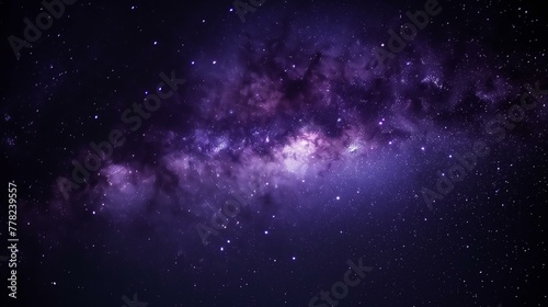A dark sky with a purple galaxy and many stars. The stars are scattered throughout the sky and the galaxy is very large