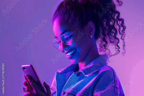 Young girl looks at the phone. Soft neon purple light all around