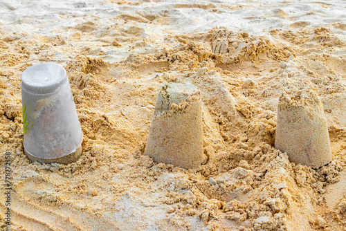 Castle made of white sand with buckets on beach Mexico.