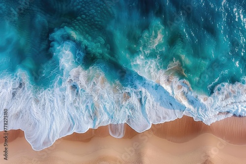 Aerial Majesty: Ocean Waves Crashing onto Sandy Beach
