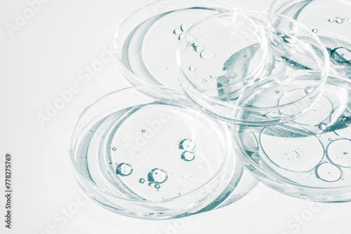 Petri dish. Petri cups with liquid. Kit. Chemical elements, oil, cosmetics. Gel, water, molecules, viruses. Close-up. On a white background.