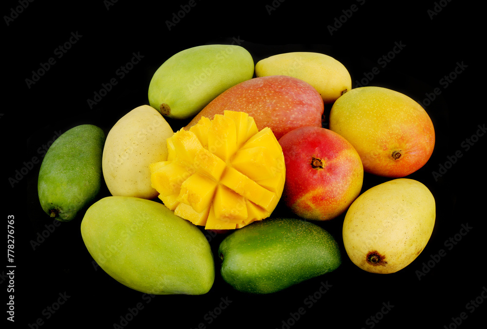 Assortment of different mangoes isolated on black background