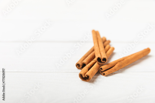 Cinnamon sticks on a textured wooden background. Cinnamon roll. Spicy spice for baking, desserts and drinks. Fragrant ground cinnamon. cinnamon powder Close-up. Place for text. copy space