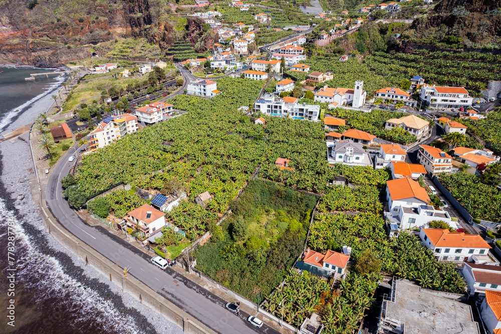 Aerial view of small farming village with banana plantation at Madeira Atlantic Ocean coast