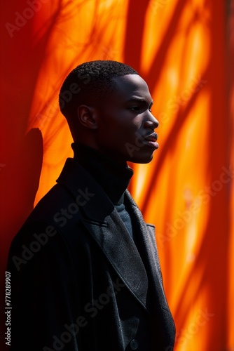 A man with a black jacket and a orange background (ID: 778289907)