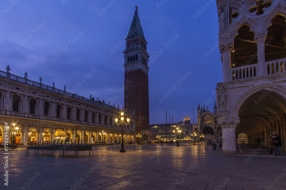 An empty illuminated San Marco square with the bell tower and Doge Palace at blue hour on a winter evening, Venice, Veneto, Italy