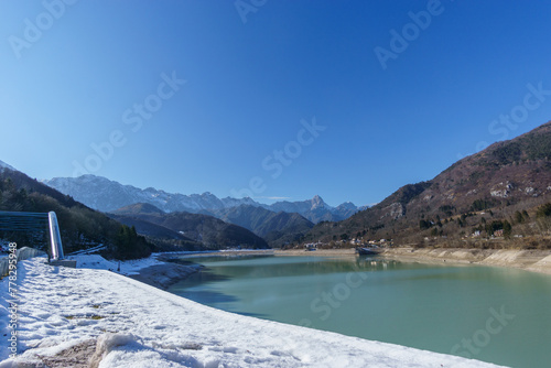 Reservoir lake during winter time with village in the mountain landscape of the Alps, Barcis, Friuli-Venezia Giulia, Italy photo