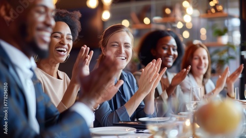 Diverse friends clapping hands, enjoying a celebration dinner at a classy restaurant.